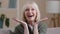 Close up excited caucasian joyful old female face. Happy shocked amazed middle-aged woman virtual activity retirement