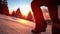 CLOSE UP: Excited female tourist runs in glistening fresh powder snow at sunset.