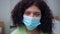 Close-up exhausted face of tired doctor in coronavirus face mask looking at camera. Overburdened Caucasian young woman