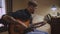 Close-up of a experienced artistic young man sitting on bed playing his guitar following his passion