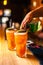 Close-up of expert bartender making colorful orange cocktails in bar