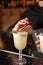 Close-up of expert bartender making white cocktail with dried lime in bar