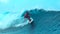 CLOSE UP: Extreme male surfboarder rides an epic barrel wave in sunny Teahupoo.