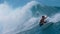 CLOSE UP: Extreme surfer spraying glassy water while carving a breaking wave.