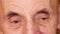 Close-up of the eye of a Caucasian elderly man 70 years old. Part of the face of a pensioner with deep wrinkles. Elderly man look.