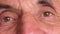 Close-up of the eye of a caucasian elderly man over 70 years old. Positive view of the pensioner. Real people. Part of the face of