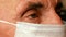 Close-up eye of an elderly Caucasian man 70-80 years old wearing a protective medical mask.Caring for the health of the elderly du