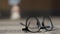 Close-up eyeglasses on the floor with unrecognizable teenagers fighting at background. Feet of angry aggressive
