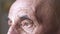 Close-up of the eyes of a caucasian pensioner with a sad look. Part of the face of an elderly man 70 years old. Wrinkles near the