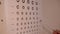 Close-up eyesight test chart with male hand pointing with pen. Unrecognizable Caucasian professional ophthalmologist