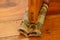 A close up of a fabric draught stopper on a wooden floor under a wooden door