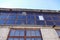 Close up of facade details of an old abandoned grey brick industrial building with glass top in Telliskivi district