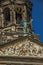 Close-up of facade with sculptures and dome with golden clock in the Royal Palace of Amsterdam.