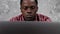 Close up face African American businessman works laptop chatting with employees