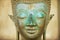 Close up of a face of an ancient copper Buddha statue outside of the Hor Phra Keo temple in Vientiane, Laos.