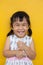 Close up face of asian kid toothy smiling facial face with happiness emotion on yellow wall use for children lovely emotion and de