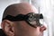 Close-up face of a bald young man wearing dark glasses, the concept of watch solar eclipse, bright welding, eye protection at work