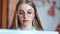 Close-up face of beautiful busy young business woman wearing glasses looking at screen of laptop