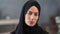 Close up face beautiful Turkish woman wearing black hijab posing at modern cosiness home interior