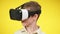 Close-up face of boy in VR headset turning head and screaming. Portrait of absorbed Caucasian gamer gaming online in