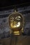 Close up face of bronze buddha statue at Bangkok temple in Thailand in Asian culture and religion