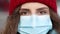 Close up of face calm serious curly haired woman wears protective mask to avoid contaminating coronavirus looks of city