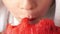 Close-up face of a Caucasian preschool boy biting a very ripe and delicious watermelon. Selective focus, shallow