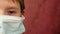 Close-up face of a Caucasian preschool boy wearing a protective medical mask. On the right is a copy space; a child in a medical m