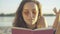 Close-up face of charming brunette young woman reading out loud. Portrait of confident beautiful Caucasian tourist in