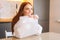 Close-up face of cheerful young woman playing pops bubble wrap to calm herself sitting at table in kitchen.