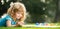 Close up face of cute child outdoors. Spring banner for website header. Artist kids. Kid draws in park laying in grass