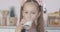 Close-up face of cute little girl drinking milk and smiling. Portrait of satisfied Caucasian brunette child with brown