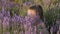 Close-up face cute little girl sitting in lavender flowers and inhaling fragrance of flowers concept rest and relaxation