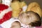 Close up face of cute sleeping newborn baby boy in drowsy eyes sleepy mood lying on bed. Portrait One Sweet little infant toddler