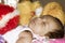 Close up face of cute sleeping newborn baby boy in drowsy eyes sleepy mood lying on bed. Portrait One Sweet little infant toddler