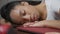 Close-up face of fatigued African American young woman sleeping on table in home office. Headshot of tired exhausted