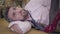 Close-up face of a handsome gray-haired Caucasian man laying on the floor. Beautiful female leg in red high-heel shoes