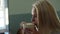 Close-up face of happy young pretty woman with long blonde hair sitting in cafe by window drinking coffee.