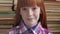 Close-up face of a little happy schoolgirl on background of books