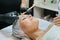 Close-up face of mature woman at cosmetic age procedures in beauty salon