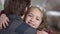Close-up face of pretty little girl hugging man looking at camera and smiling. Portrait of happy Caucasian daughter