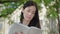 Close-up face of serious absorbed Caucasian woman reading book at university yard. Portrait of concentrated brunette