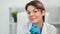 Close-up face of smiling beautiful mature woman scientist in safety glasses white coat and gloves