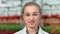 Close-up face of smiling female agricultural biologist in glasses enjoying break looking at camera