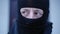 Close-up face of suspicious Caucasian man in ski mask looking around and looking at camera with brown eyes. Cautious