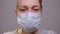 Close-up of the face of a woman putting on several medical masks