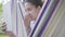 Close-up face of young African American woman sitting in the hammock, relaxing in the garden, texting on her tablet