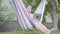 Close-up face of young African American woman sitting in the hammock, relaxing in the garden, texting on notebook