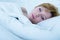 Close up face of young attractive woman with red hair sleeping peacefully lying in bed at home