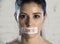 Close up face of young beautiful sad latin woman with mouth sealed on stick tape with the text no food